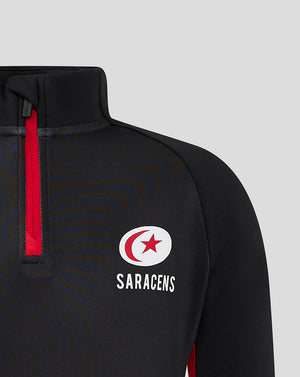 Close up of black quarter zip top with red zipper and Saracens crest on chest