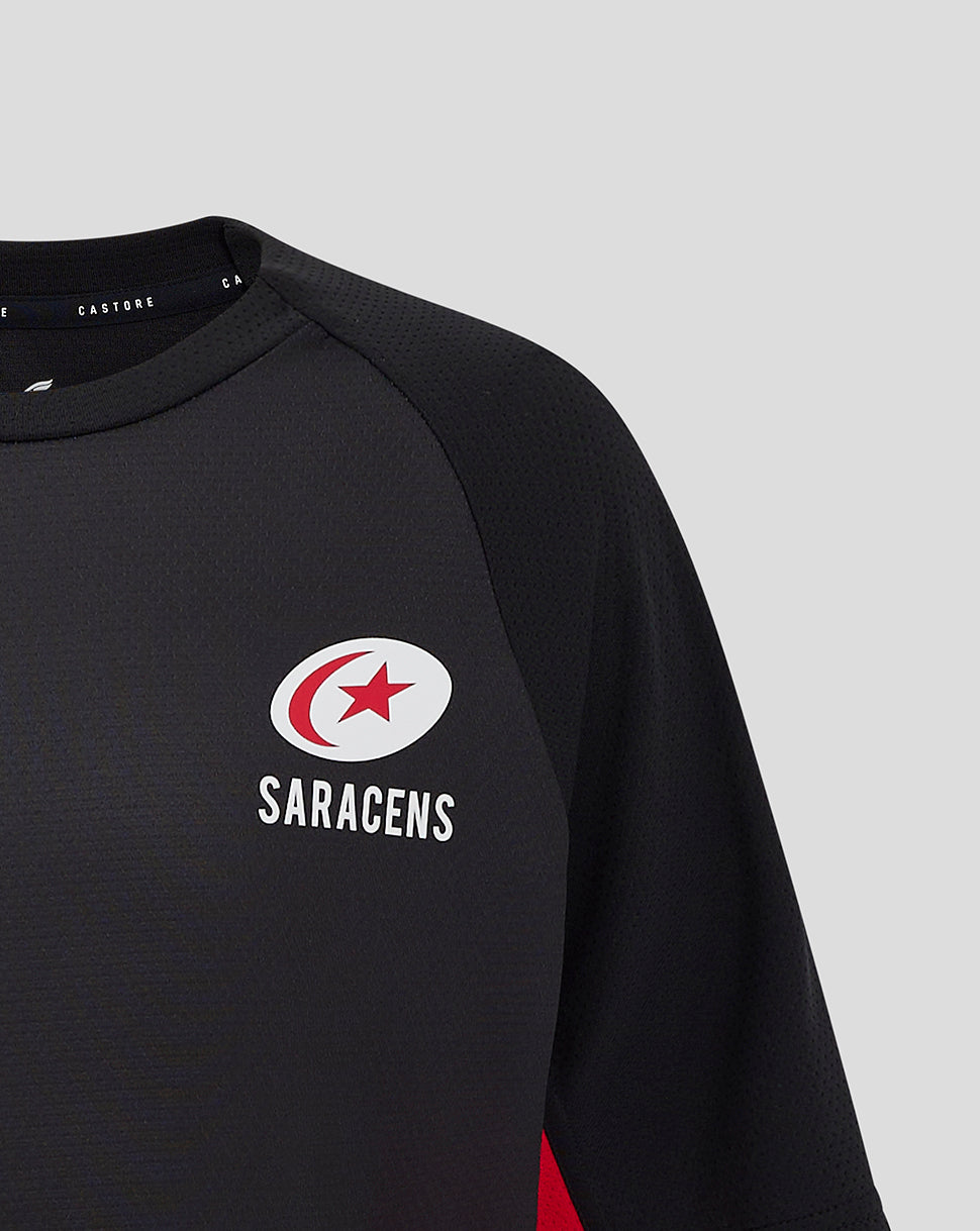 Close-up of chest showing the circular Saracens crest on the black matchday tee.