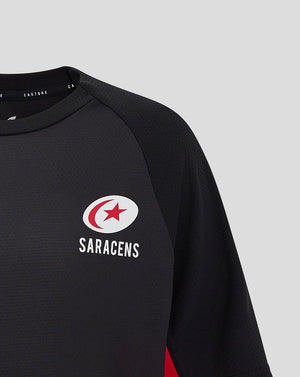 Close-up of chest showing the circular Saracens crest on the black matchday tee.