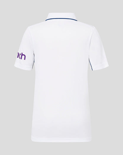 Back view of white infant England cricket short sleeve shirt with blue piping at the collar and purple cinch text on the left sleeve
