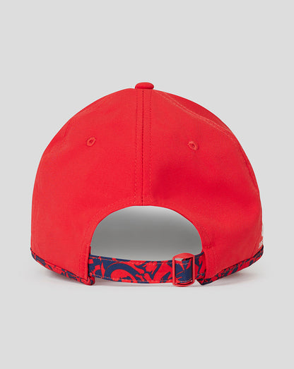 Rear view of fiery red England cricket junior T20 cap showing adjustable buckle and blue patterned strap.