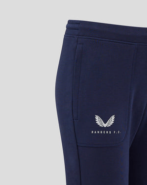 Close-up of navy Rangers FC junior travel pants with white logo on left calf