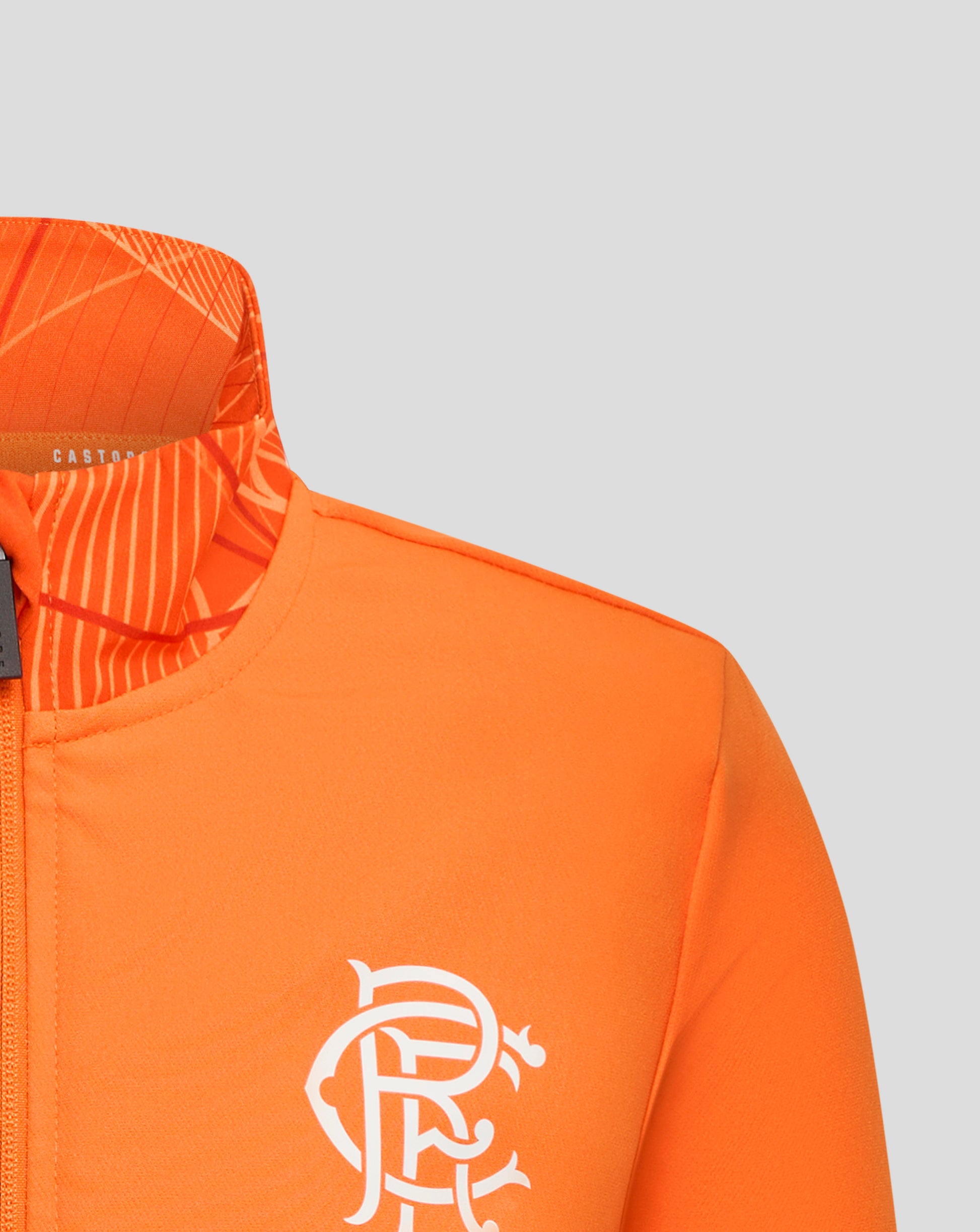 Close up of the orange jacket chest with a large white crest partially visible and the patterned collar edge.