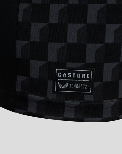 Close-up of Mansfield Junior shirt fabric with a dark checkerboard pattern and Castore label patch
