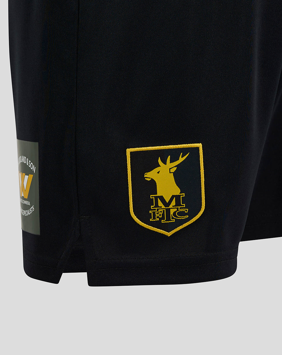 Close-up of the lower right leg with the yellow MFTC shield crest embroidered on the shorts