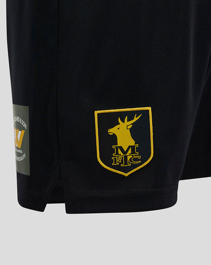Close-up of the lower right leg with the yellow MFTC shield crest embroidered on the shorts