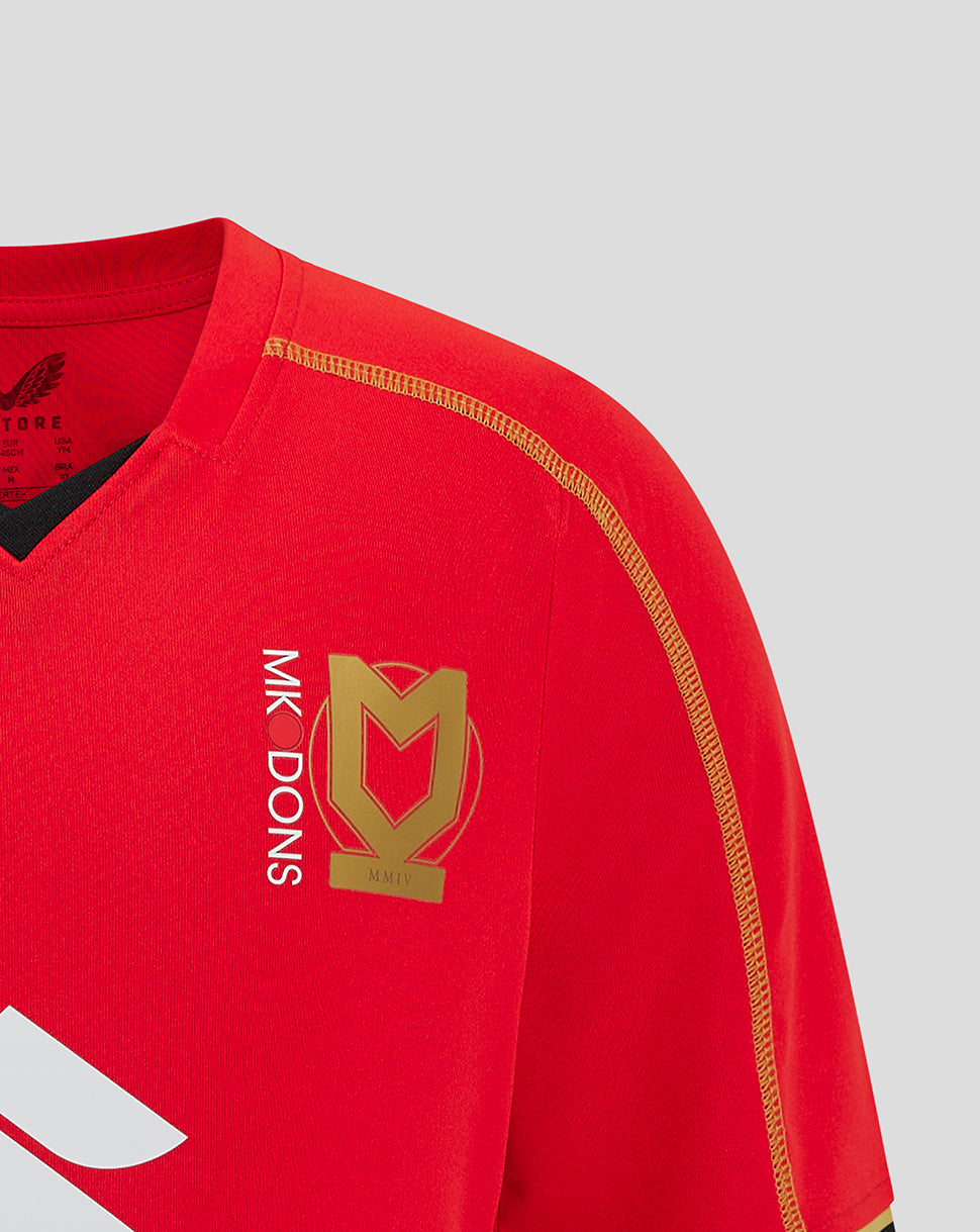 Mk Dons Junior 24/25 away shirt in red with gold crest on chest and gold shoulder piping.