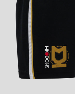 Close up of the side seam on black Mk Dons Junior 24/25 Third Shorts showing white and gold stripes and logos