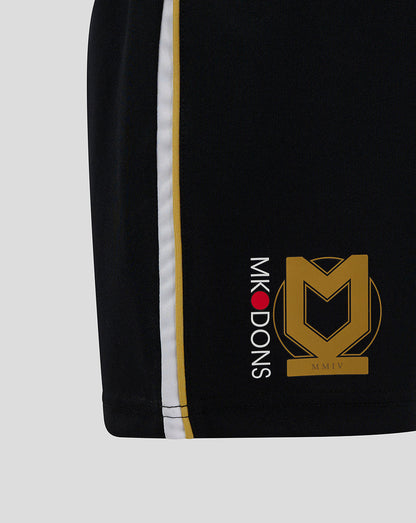 Close up of the side seam on black Mk Dons Junior 24/25 Third Shorts showing white and gold stripes and logos
