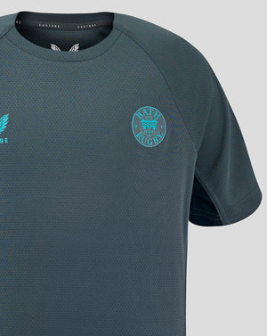 Front close-up of Bath Rugby Junior training T shirt showing turquoise left chest crest and Castore branding on right chest