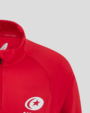 Close-up of red Saracens training top showing collar branding and chest crest.