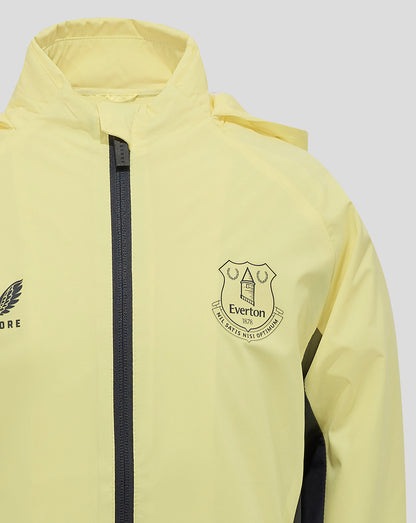 Close-up of the chest displaying the Everton crest beside a dark zipper on pale yellow fabric
