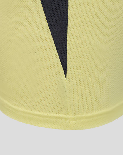 Close-up of the pale yellow fabric with a dark navy V shaped panel and textured mesh material at the hem.