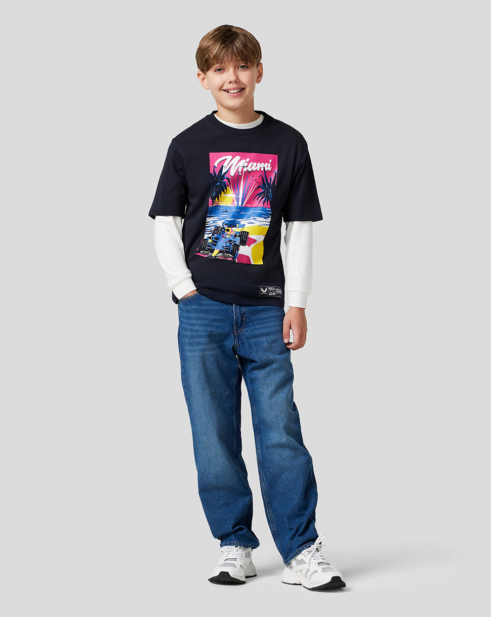Full length of a boy in a navy Miami graphic T shirt with a colorful front print, jeans and sneakers