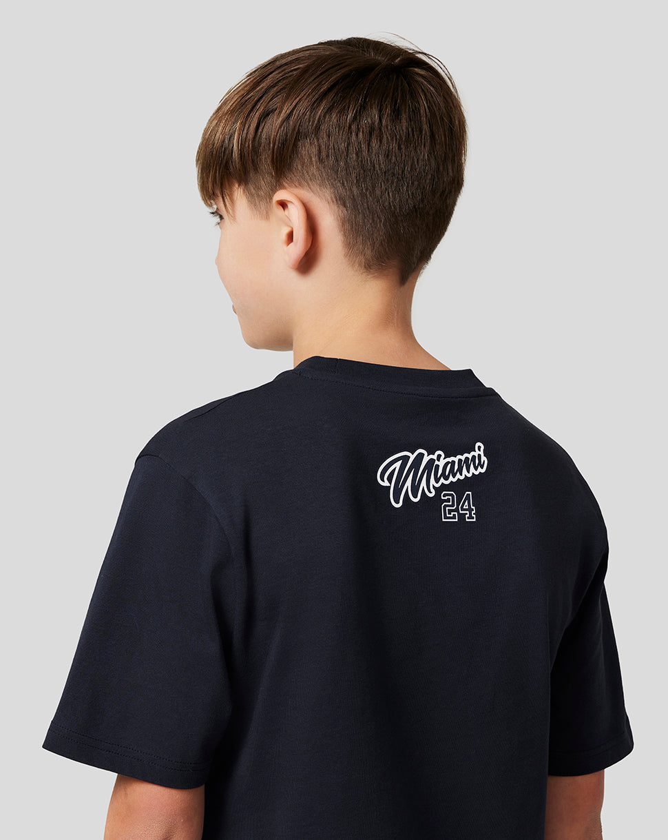 Rear view of a young boy wearing a navy Miami graphic T shirt with white Miami script and the number 24 on the back
