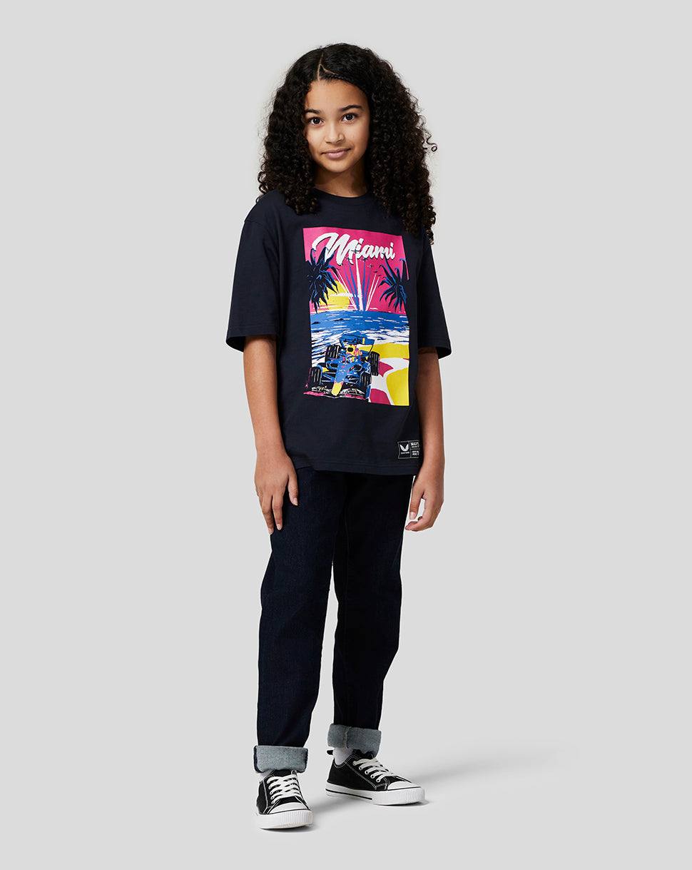 Girl wearing a navy Miami graphic T shirt with a bold front print over a white long sleeve tee, paired with jeans and sneakers