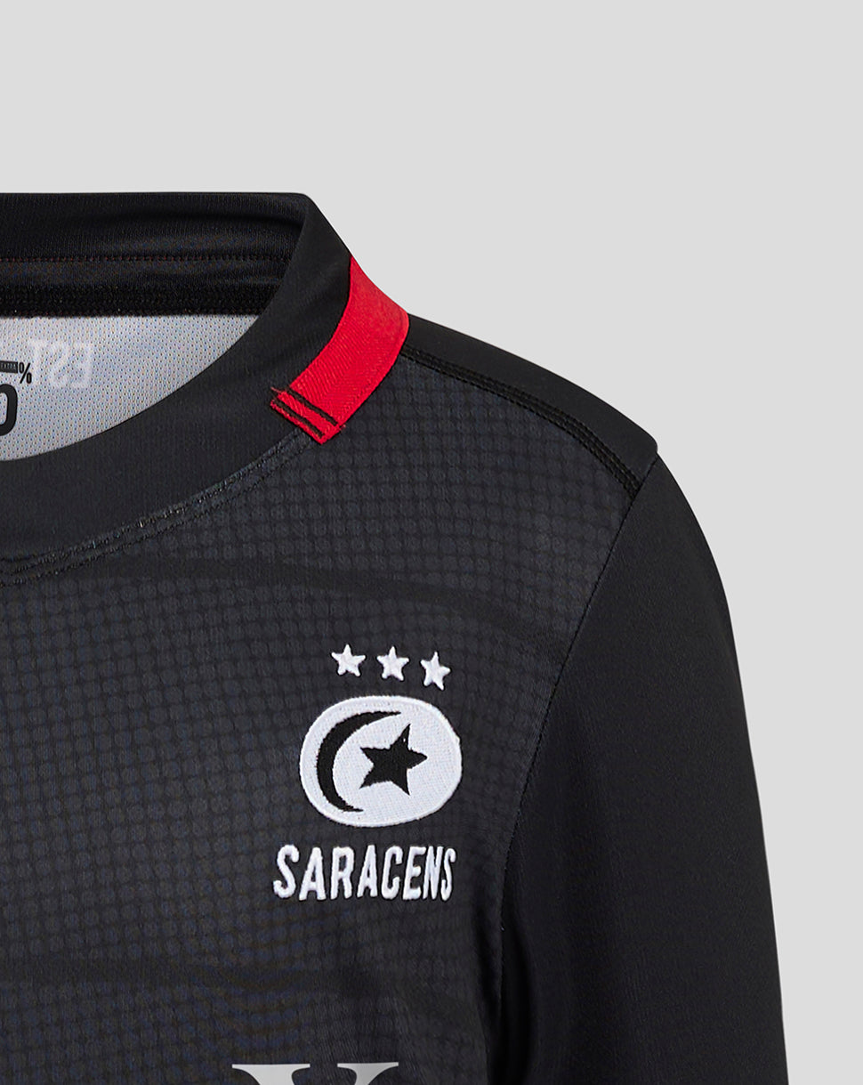 Close-up of Saracens crest on the chest with three stars above, dark textured fabric and a red collar tab.