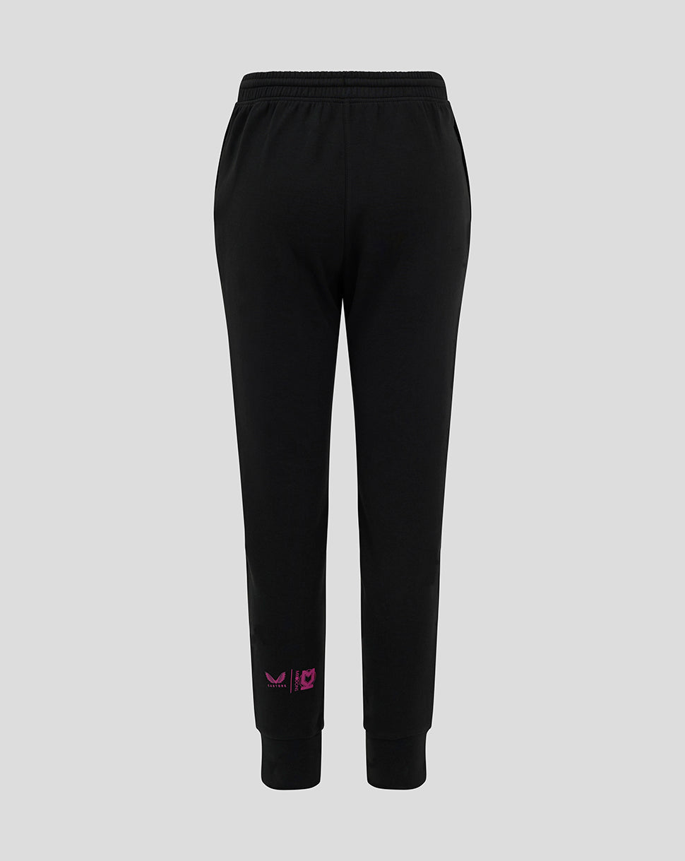 Back view of black Mk Dons junior travel pants with pink logo near the lower leg