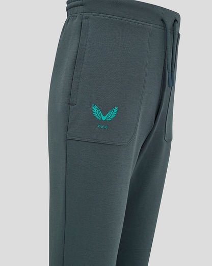Side view of dark teal Preston Junior 24/25 Travel Pant featuring a thigh pocket and teal logos.