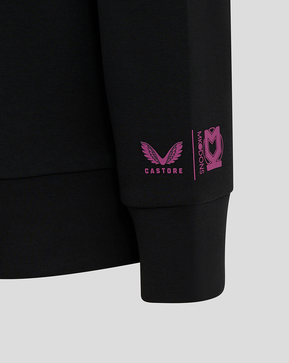 Close-up of pink Castore logo and Mk Dons branding on the black sleeve