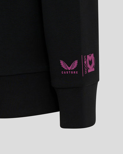 Close-up of pink Castore logo and Mk Dons branding on the black sleeve