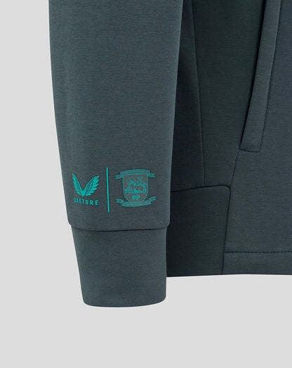 Teal Castore emblem and PNE crest printed on the dark teal sleeve of the junior travel jacket