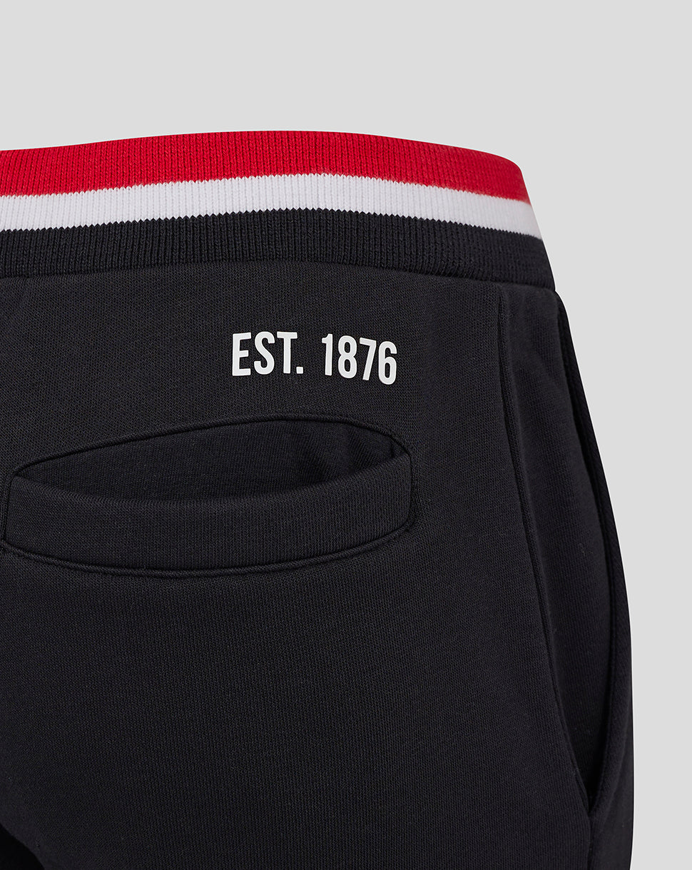 Back view of black Saracens Junior Classic Joggers with EST 1876, back pocket and red white striped cuffs.
