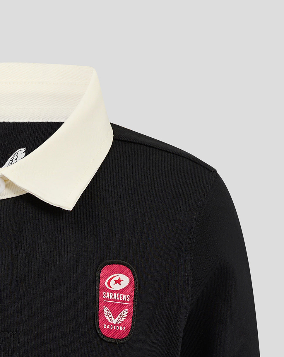 Close-up of black Saracens junior rugby jersey with cream collar and pink crest on chest