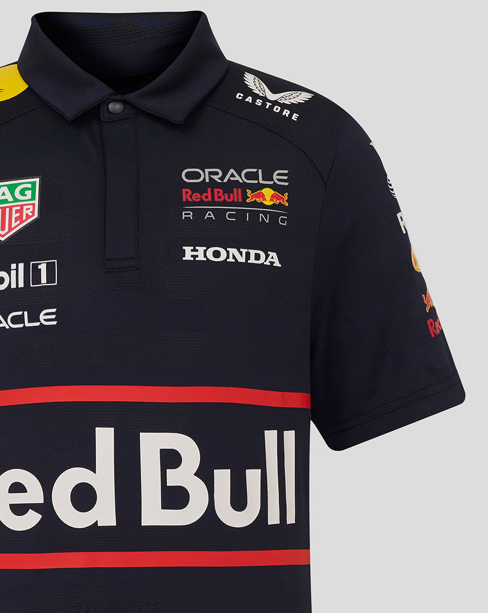 Front view of navy junior polo with Oracle Red Bull Racing branding and sponsor badges including Castore Mobil Oracle and TAG Heuer