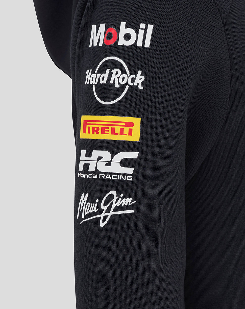 Close-up of a black team hoodie sleeve with sponsor logos including Mobil, Hard Rock, Pirelli, Honda Racing and Maui Jim