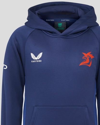 Close up of navy hoodie with hood; white wing Castore logo on left chest and red rooster emblem on right; interior tag visible