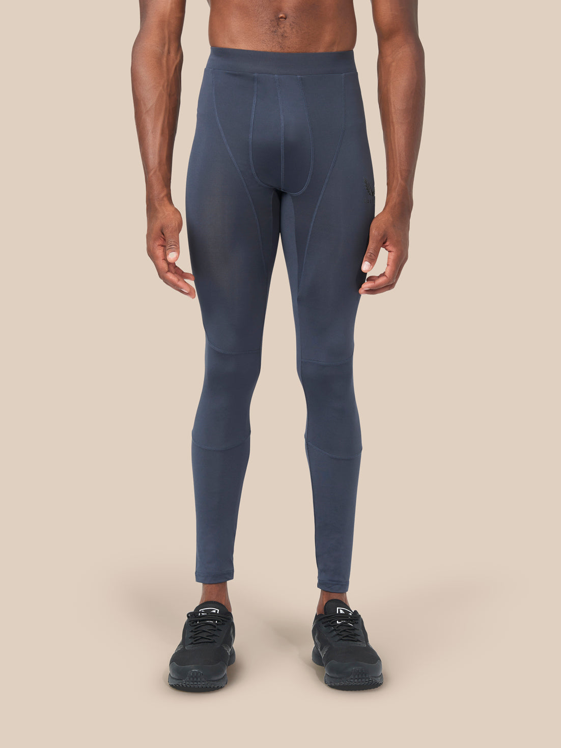 Front view of a male model wearing navy Active Base Layers leggings with black sneakers