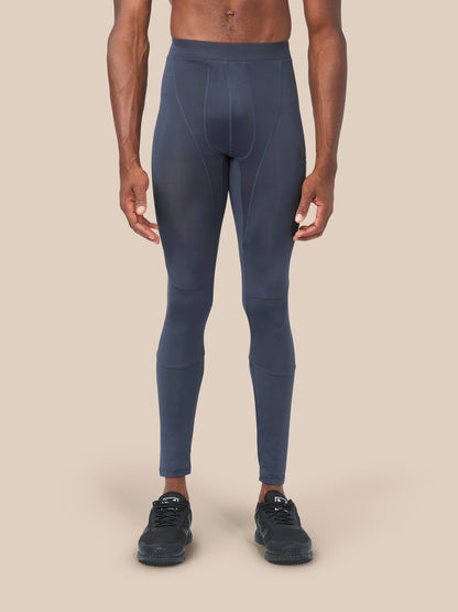 Front view of a male model wearing navy Active Base Layers leggings with black sneakers