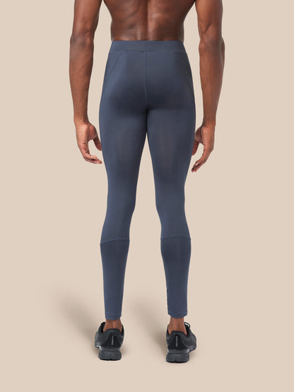 Back view of navy leggings on a model with visible waistband and seam panels