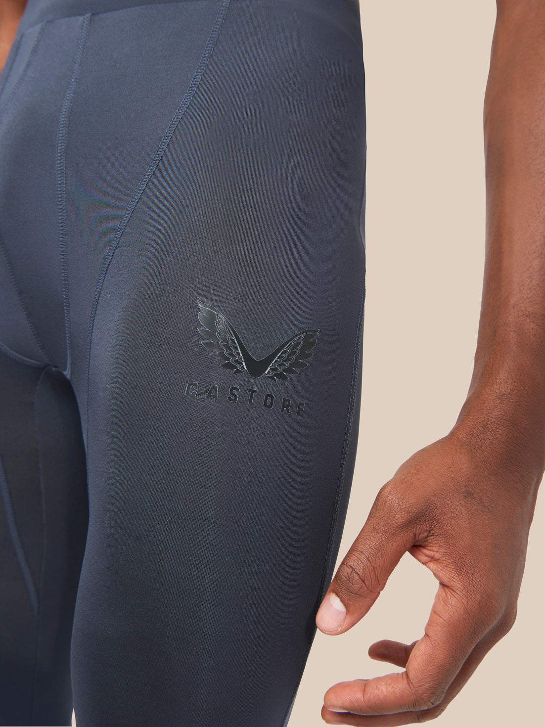 Close-up of navy leggings thigh showing wing logo and GASTORE text