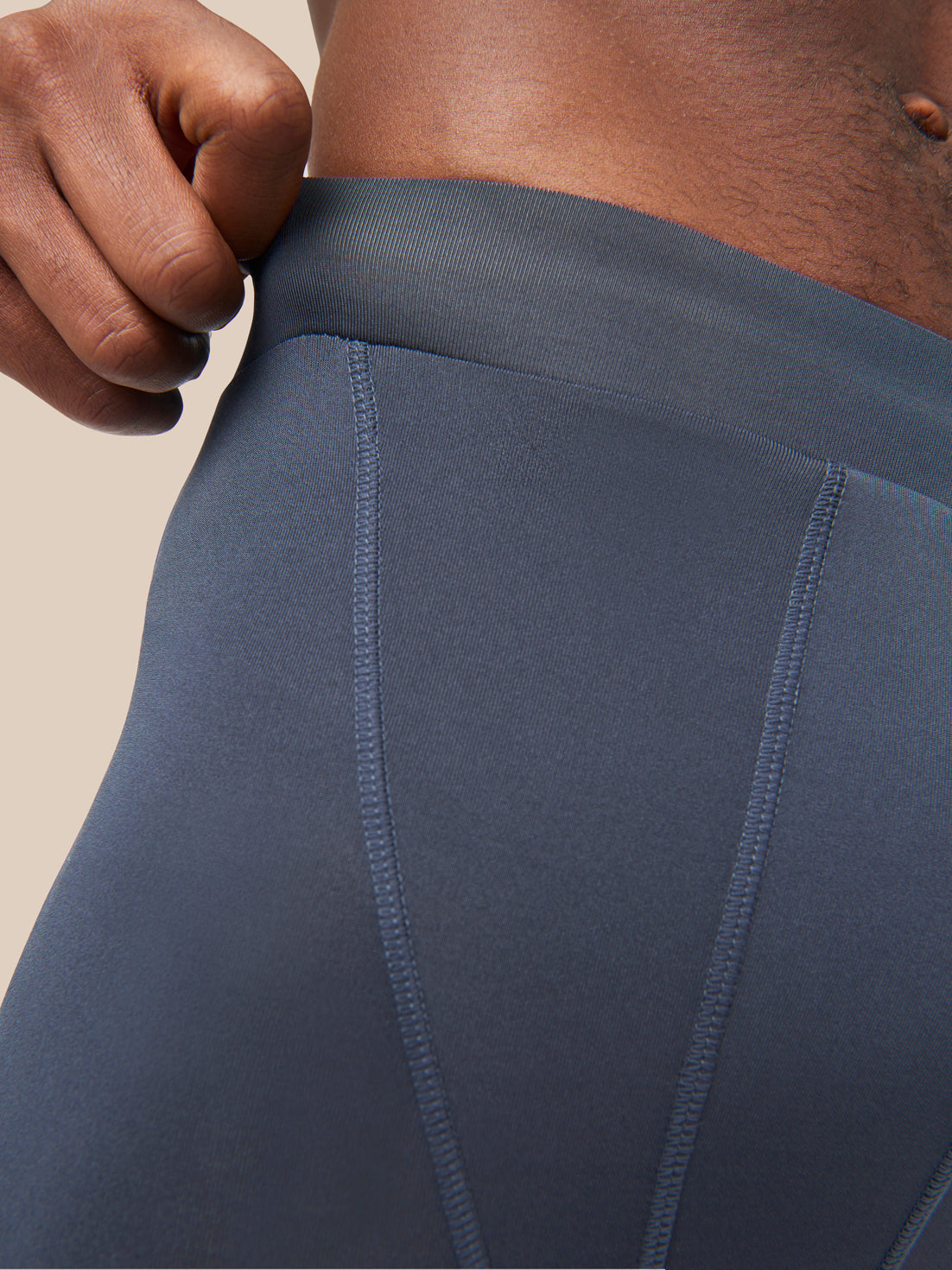 Close-up of blue Active Base Layers leggings waistband with stitching details.