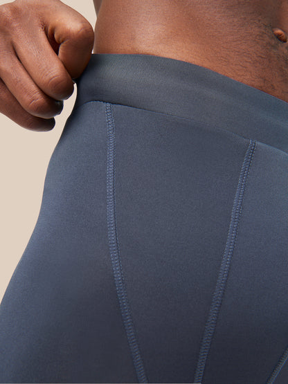 Close-up of blue Active Base Layers leggings waistband with stitching details.