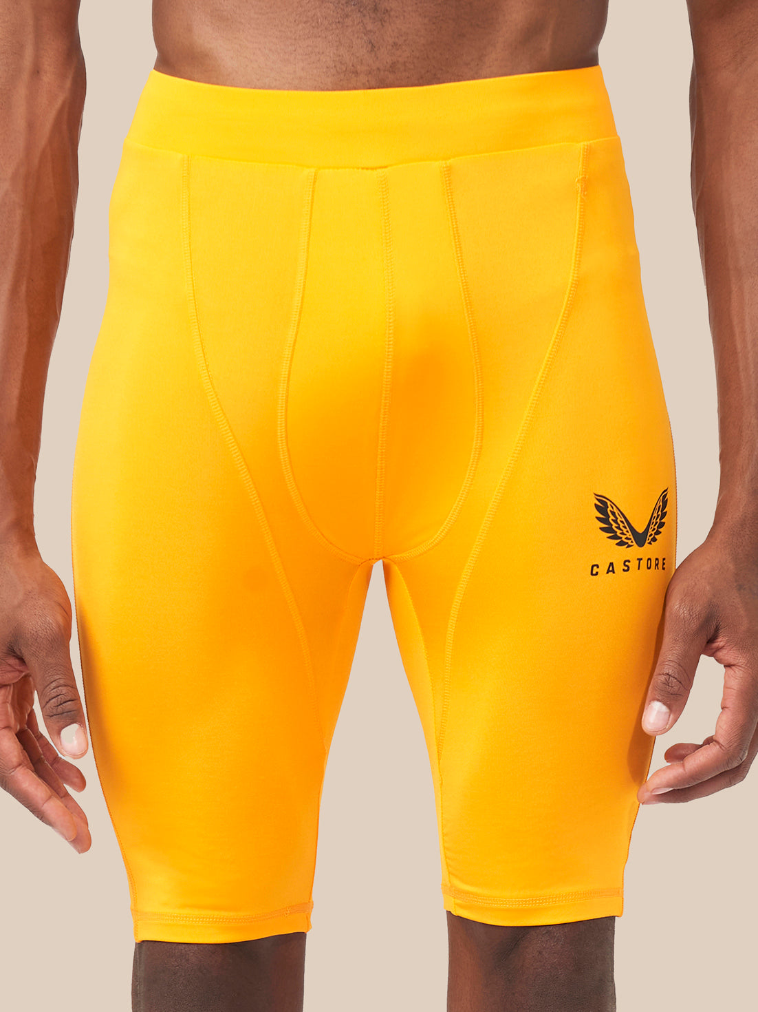 Front view of bright yellow Active Base Layer Shorts with panel seams and Castore logo on the thigh