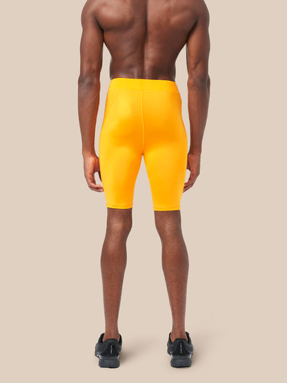 Back view of a male model wearing bright yellow Active Base Layer Shorts mid thigh length