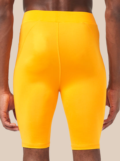 Back view of bright zinnia orange Active Base Layer Shorts on a model