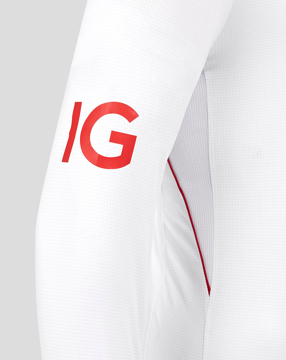 Close up of white cricket shirt sleeve with bold red IG lettering.