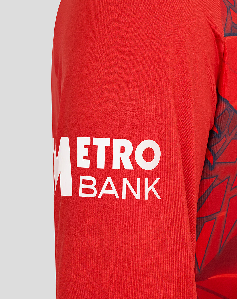 Close-up of the red England Cricket T20 sweater sleeve with white Metro Bank logo.