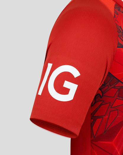 Close-up of a red England T20 shirt sleeve with bold white lettering and a geometric side panel