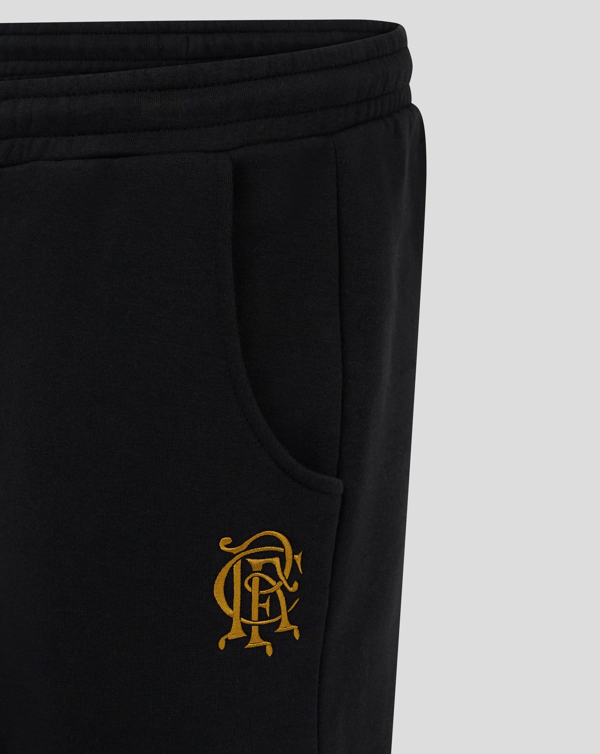 Close up of the back hip area on black Rangers FC joggers showing gold crest embroidery beside the pocket
