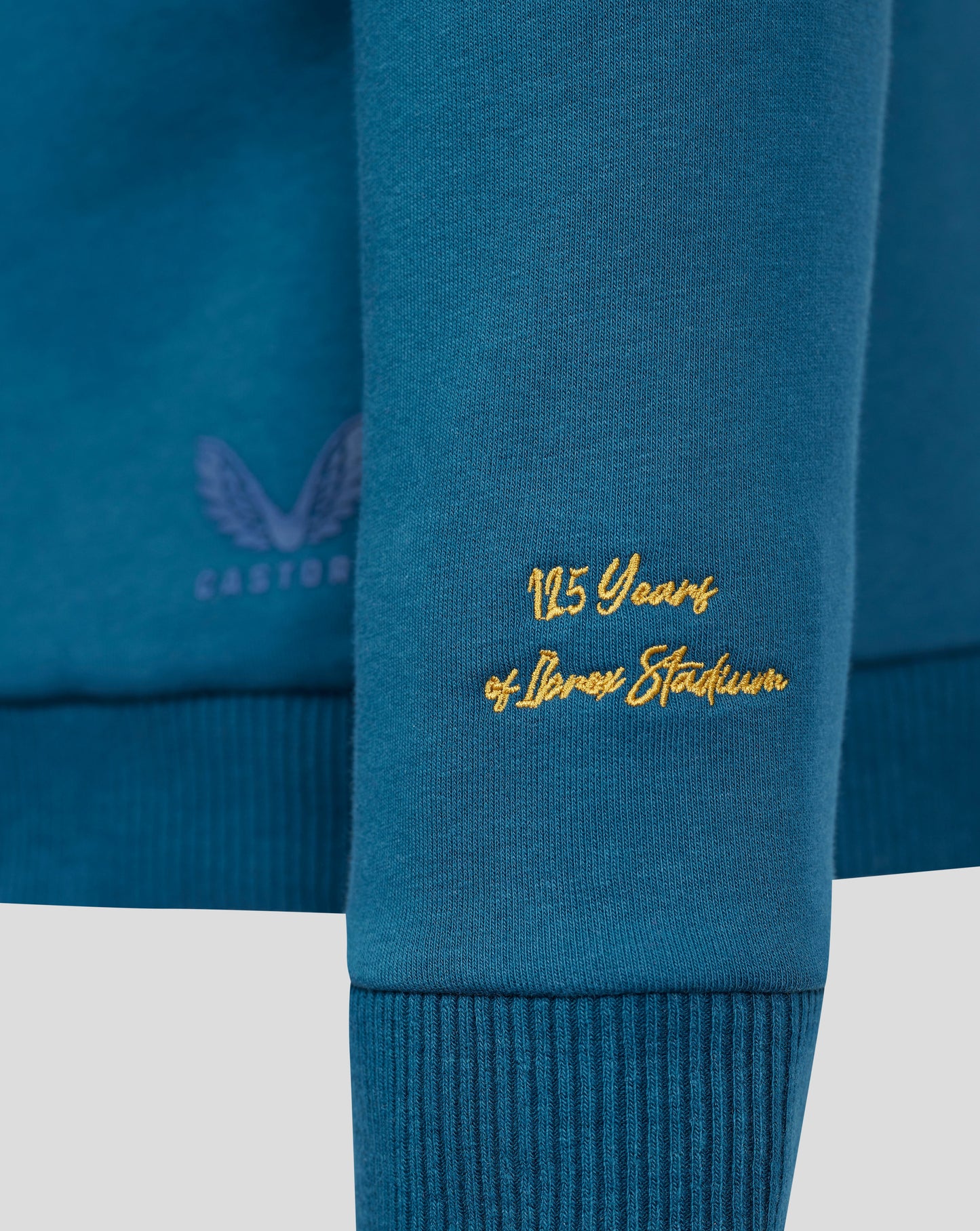 Close-up of blue Rangers sweatshirt hem showing gold 125 Years embroidery and partial crest