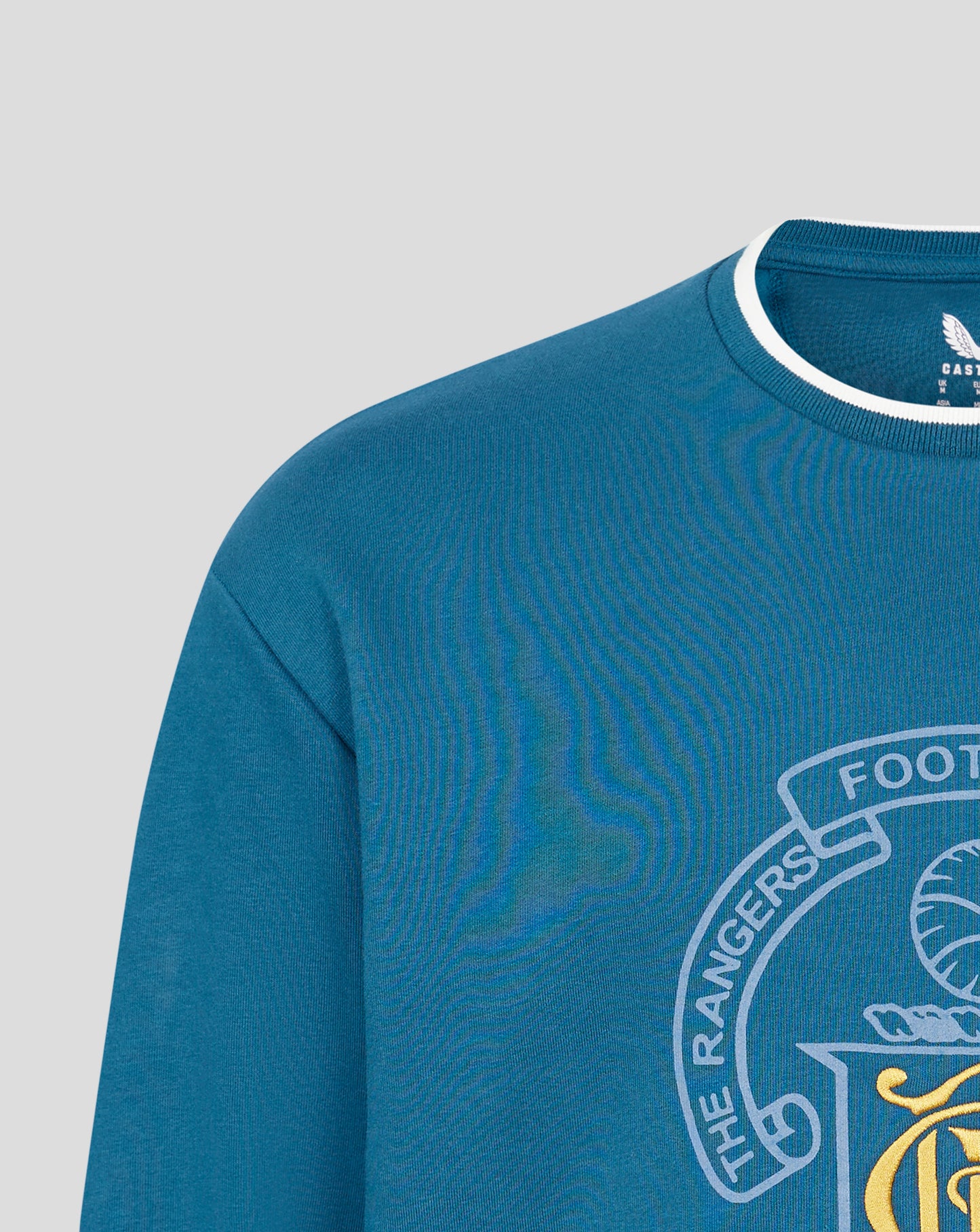 Close-up of blue crewneck neckline with white trim and a partial chest crest