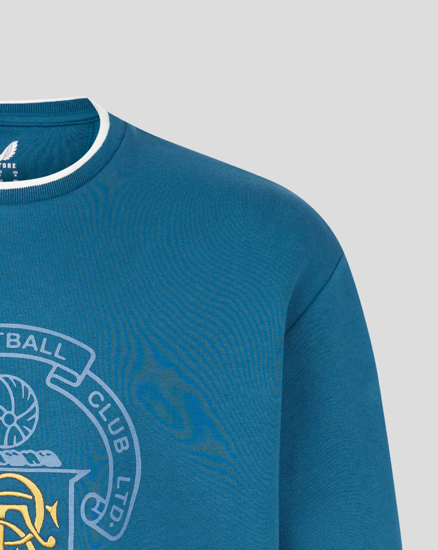 Close-up of blue Rangers FC heritage crewneck showing ribbed collar with white trim.