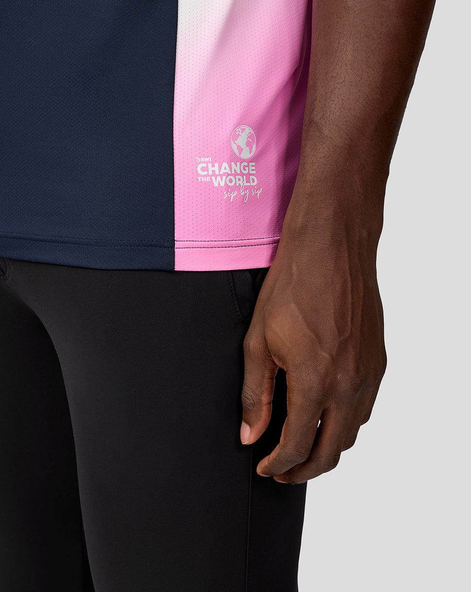 Side view of the navy BWT Alpine polo featuring a pink color block and Change the World logo