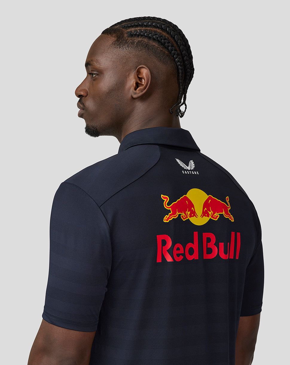 Model seen from behind in a navy Red Bull Racing polo, with large Red Bull logo and team branding on the back