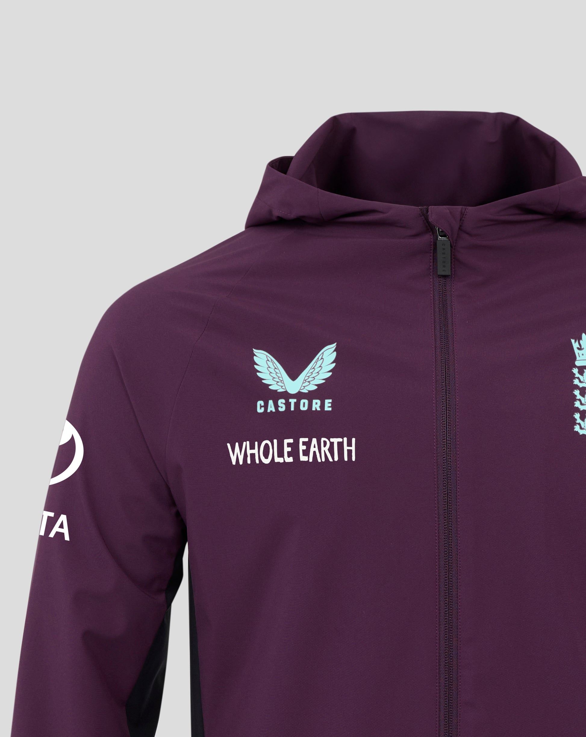Front close up of a purple England Cricket Pro Training Rain Jacket with hood and zipper, light blue Castore logo on the left chest and England crest on the right chest, Whole Earth text visible